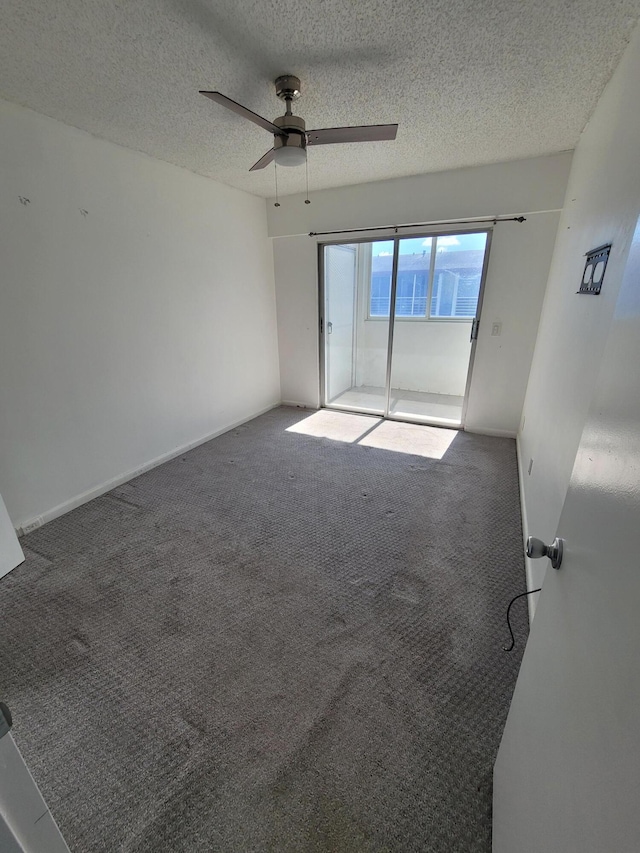 carpeted spare room featuring ceiling fan and a textured ceiling