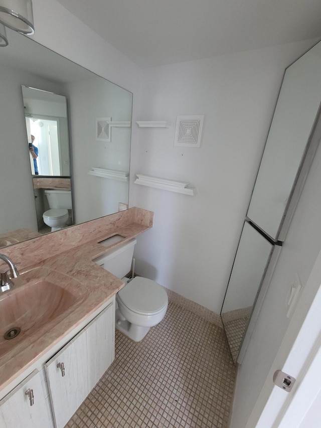 bathroom featuring tile patterned floors, vanity, and toilet