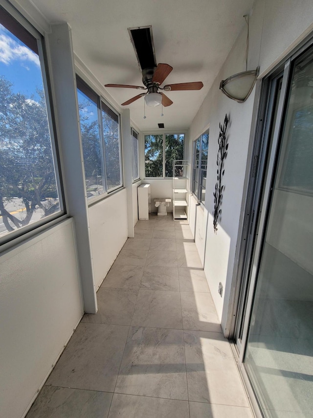 unfurnished sunroom with ceiling fan and a healthy amount of sunlight