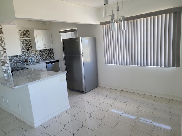 kitchen featuring white cabinets, light stone countertops, a notable chandelier, kitchen peninsula, and stainless steel appliances