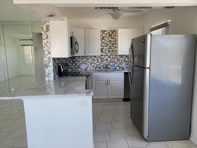 kitchen with backsplash, sink, white cabinets, and appliances with stainless steel finishes