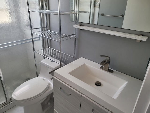 bathroom with vanity, toilet, and a shower with shower door