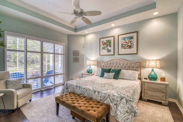 bedroom with ceiling fan, light hardwood / wood-style flooring, access to outside, and a tray ceiling