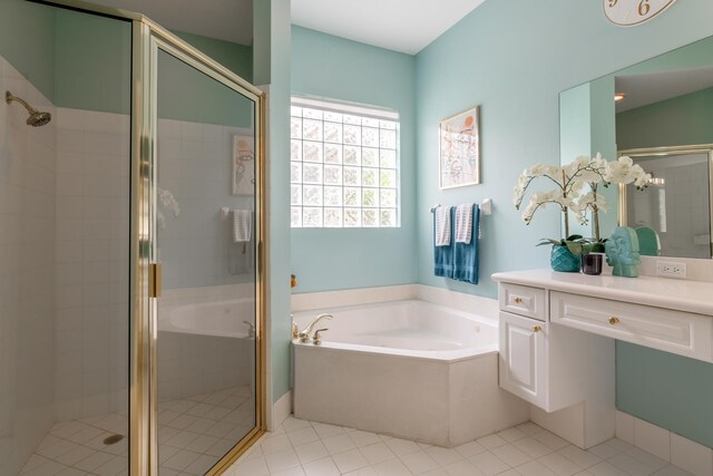 bathroom featuring a bath, a stall shower, tile patterned floors, and vanity