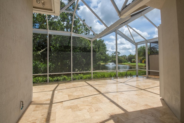 unfurnished sunroom featuring a water view and view of scattered trees