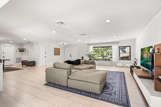 living room with light tile patterned floors and crown molding