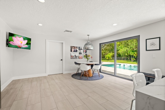 dining area featuring light hardwood / wood-style floors and a textured ceiling