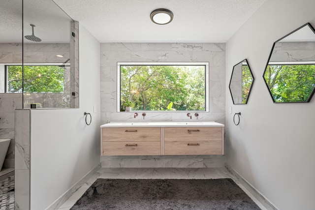 bathroom with vanity, a textured ceiling, and tile walls