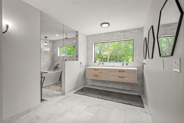 bathroom featuring vanity, separate shower and tub, and a textured ceiling