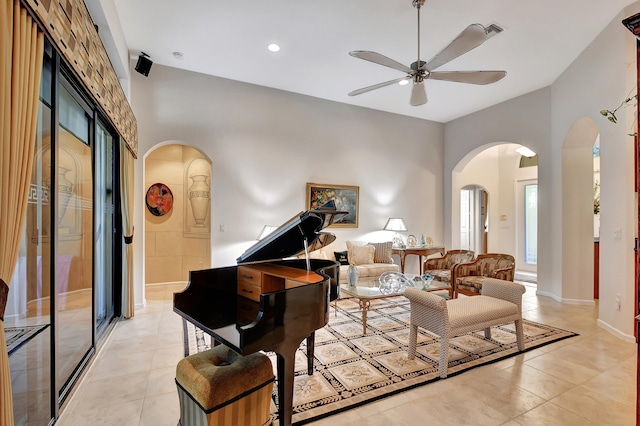 living room featuring ceiling fan, a towering ceiling, and light tile patterned floors