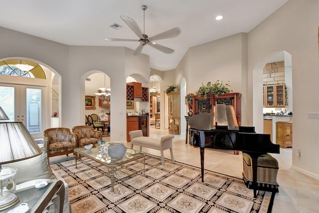 living room featuring french doors, ceiling fan with notable chandelier, and high vaulted ceiling