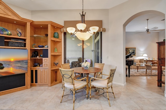 tiled dining room with ceiling fan with notable chandelier