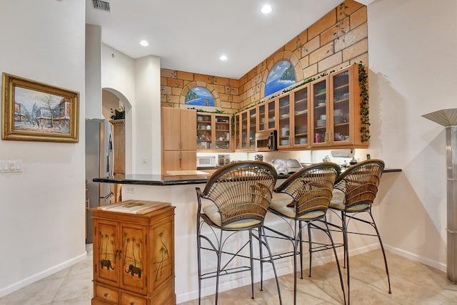 bar with stainless steel appliances and light tile patterned flooring