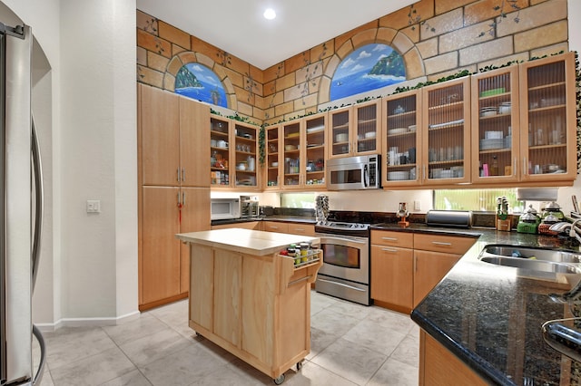 kitchen with a kitchen island, sink, stainless steel appliances, and light tile patterned flooring