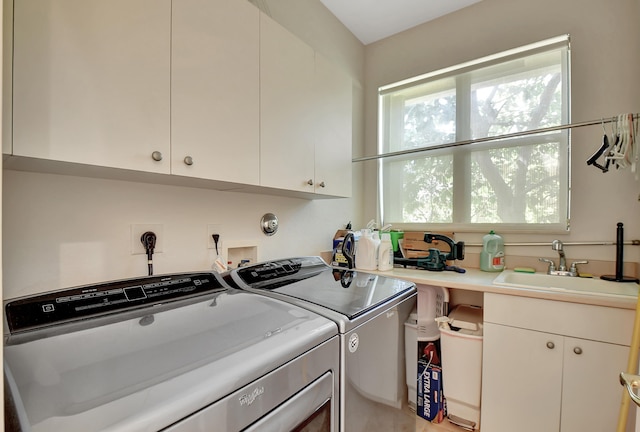 washroom with cabinets, separate washer and dryer, and sink