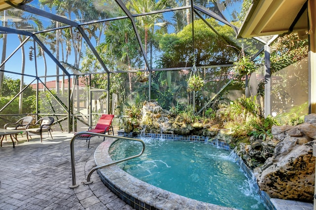 view of swimming pool with pool water feature, a patio, and a lanai