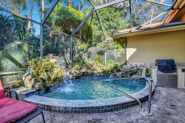 view of swimming pool with glass enclosure, pool water feature, and area for grilling