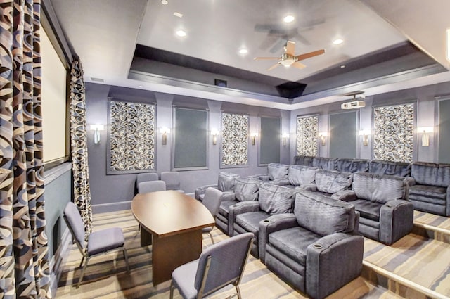 cinema room featuring ceiling fan, a raised ceiling, and carpet floors