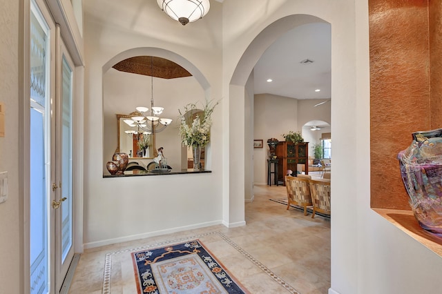 tiled foyer entrance featuring a high ceiling and an inviting chandelier