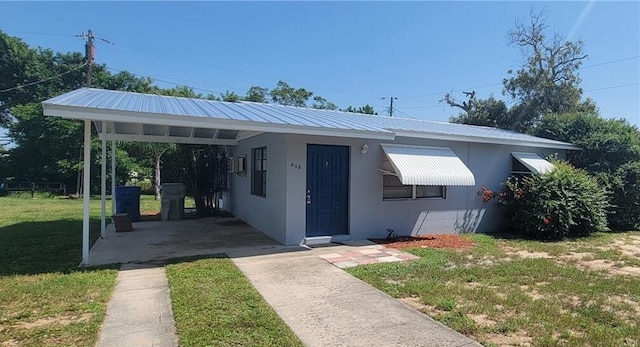 view of front of house featuring a carport and a front yard