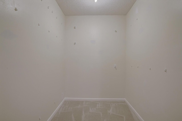 spare room with light colored carpet and a textured ceiling