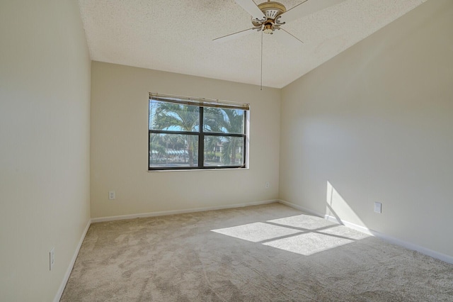 unfurnished room with ceiling fan, vaulted ceiling, light colored carpet, and a textured ceiling