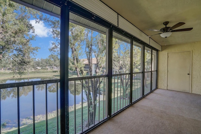 unfurnished sunroom featuring a water view and ceiling fan