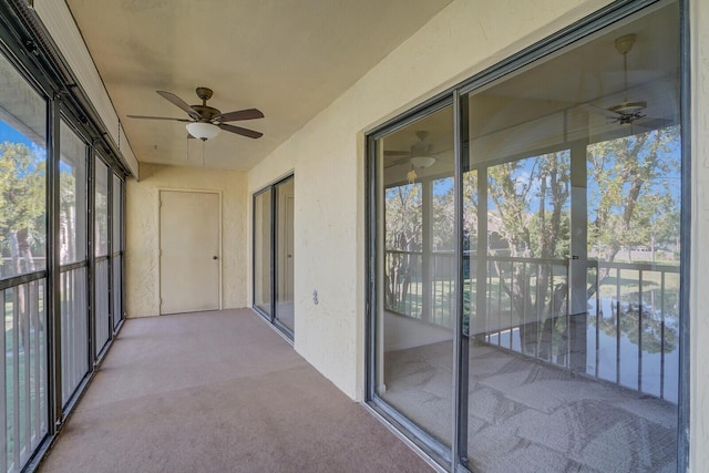 unfurnished sunroom with ceiling fan