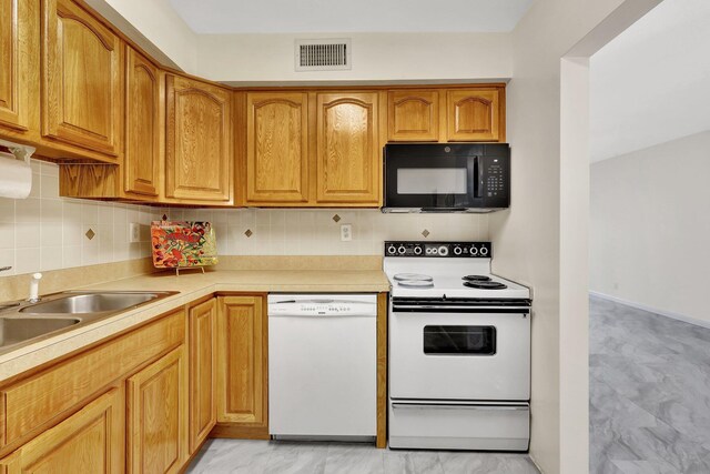 kitchen featuring tasteful backsplash, sink, and white appliances