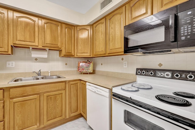 kitchen featuring white appliances, backsplash, and sink