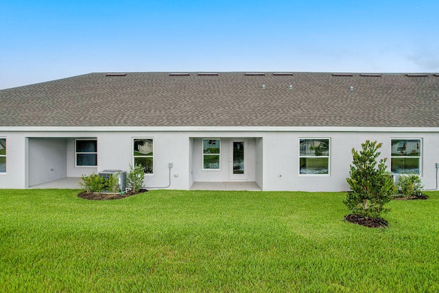 back of house featuring central air condition unit, a patio area, and a lawn