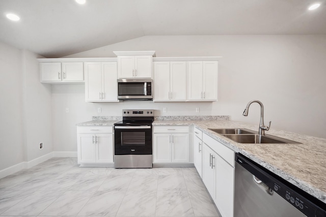 kitchen featuring stainless steel appliances, vaulted ceiling, white cabinetry, and sink