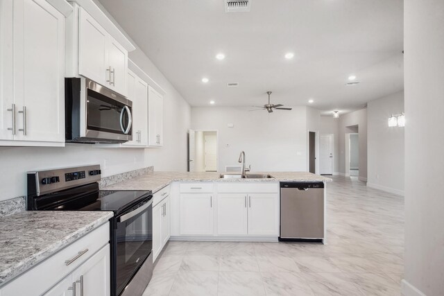 kitchen featuring sink, kitchen peninsula, ceiling fan, appliances with stainless steel finishes, and white cabinetry