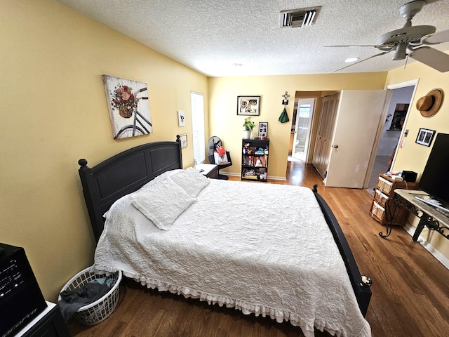 bedroom with hardwood / wood-style flooring, ceiling fan, and a textured ceiling