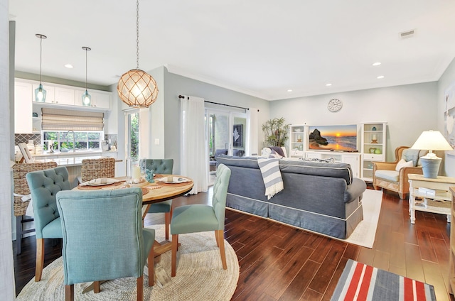 dining room with dark hardwood / wood-style flooring and crown molding