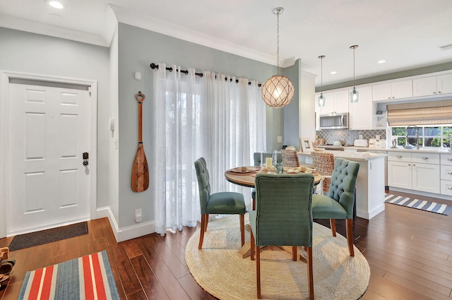 dining space featuring dark hardwood / wood-style flooring and ornamental molding