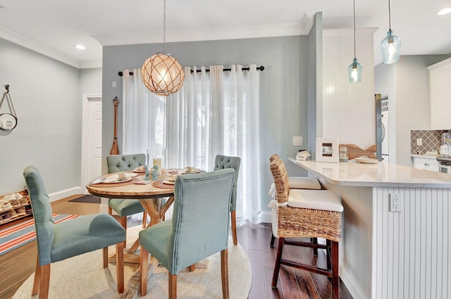 dining area featuring hardwood / wood-style flooring and ornamental molding