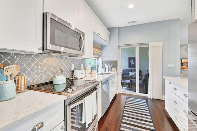 kitchen featuring white cabinetry, stainless steel appliances, and dark wood-type flooring