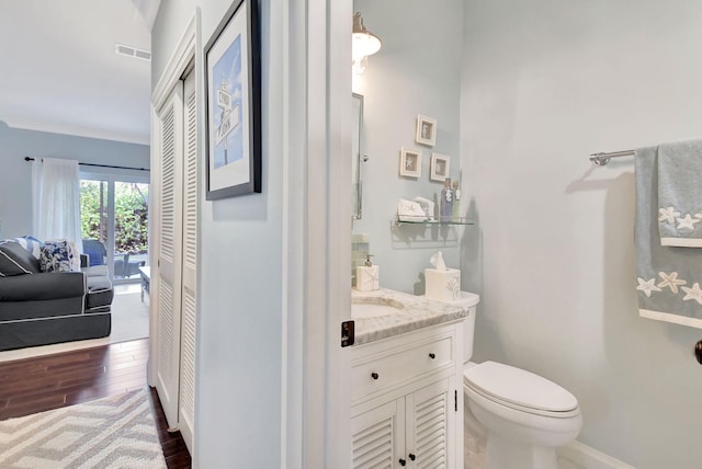 bathroom featuring hardwood / wood-style floors, vanity, and toilet