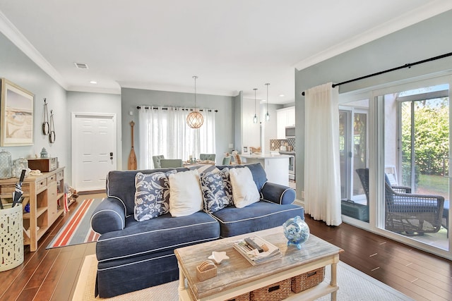 living room featuring hardwood / wood-style floors, a notable chandelier, and ornamental molding