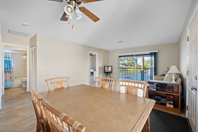 dining room with a textured ceiling and ceiling fan