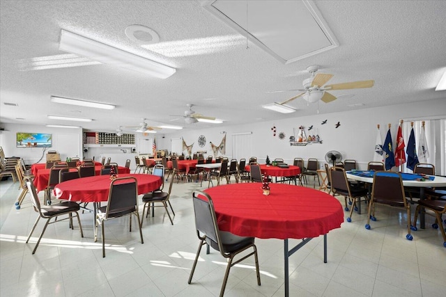 dining room featuring ceiling fan and a textured ceiling