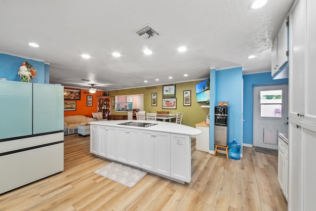 kitchen featuring a textured ceiling, black electric cooktop, light hardwood / wood-style flooring, a center island, and white cabinetry