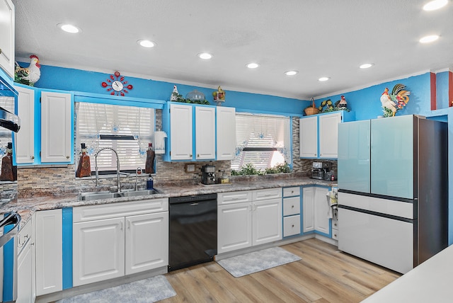 kitchen featuring sink, white cabinets, light hardwood / wood-style floors, and black dishwasher