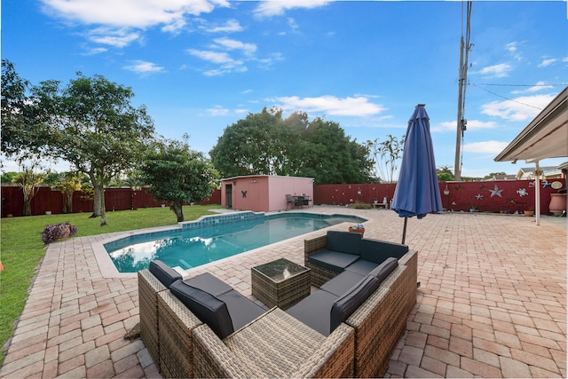 view of swimming pool with a storage unit, a yard, and a patio