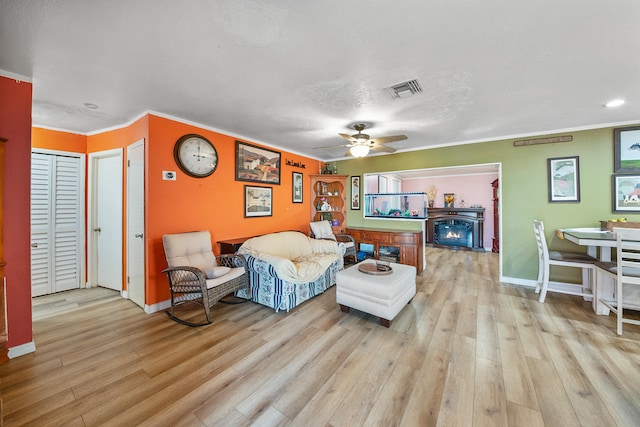 bedroom with a textured ceiling, light wood-type flooring, and ceiling fan