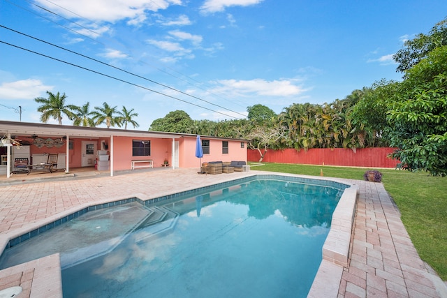 view of swimming pool featuring a lawn, ceiling fan, and a patio