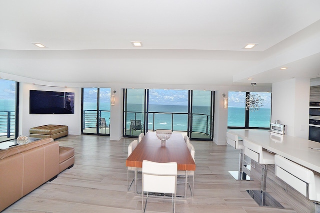 living room featuring a water view, light wood-type flooring, and built in desk