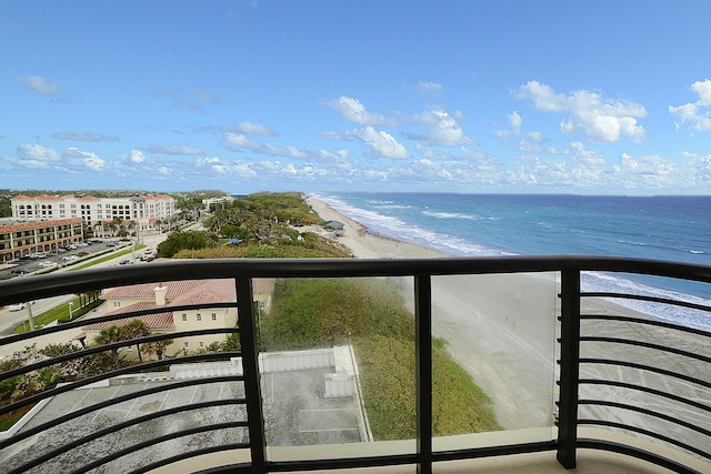 balcony with a water view and a view of the beach