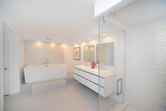 bathroom featuring a shower with door and vanity